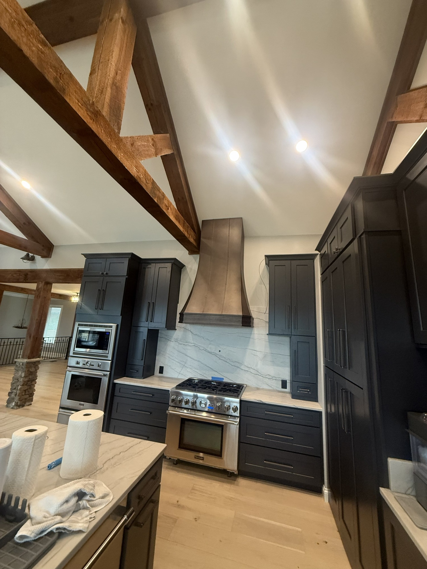 Finished custom kitchen in a home with concealed HVAC work and exposed wood beams